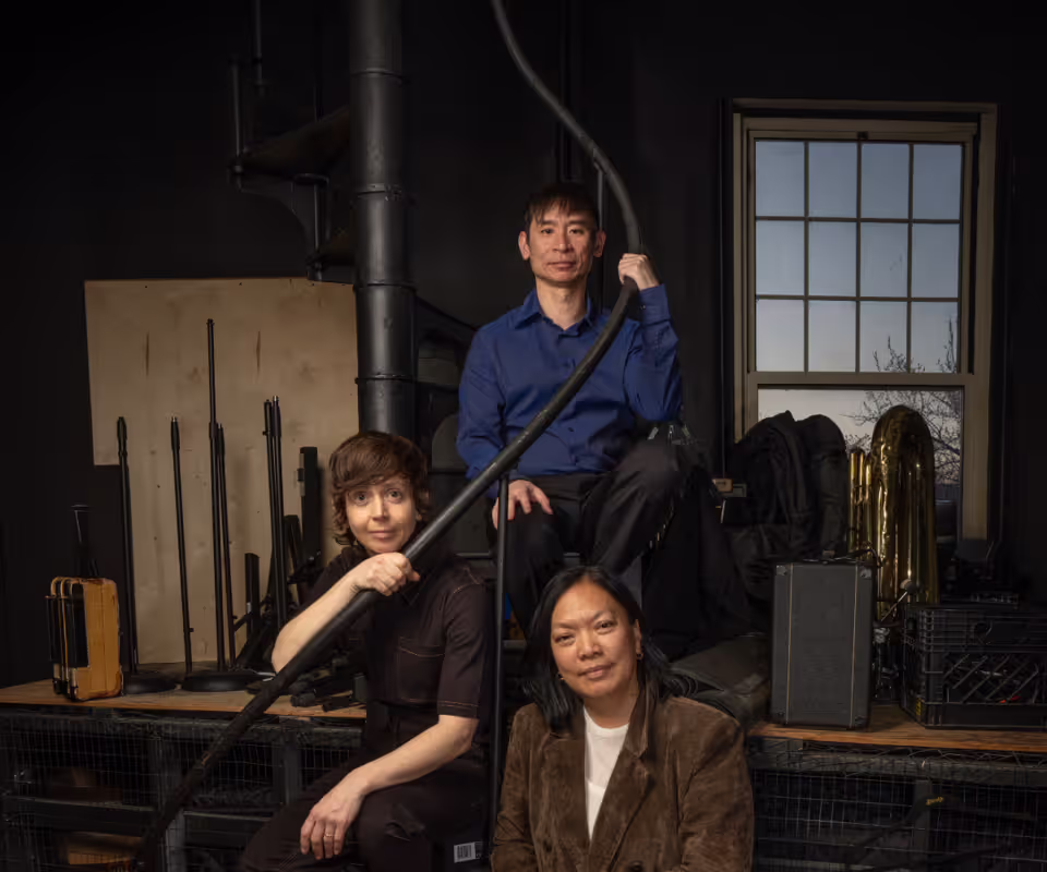 three people posed on a spiral staircase