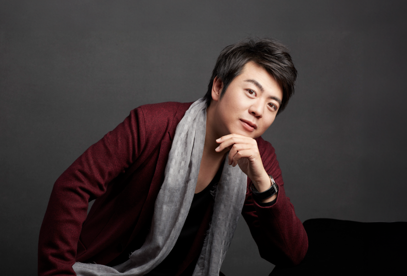 Portrait of Lang Lang in a maroon jacket and gray scarf, leaning forward with chin on hand.