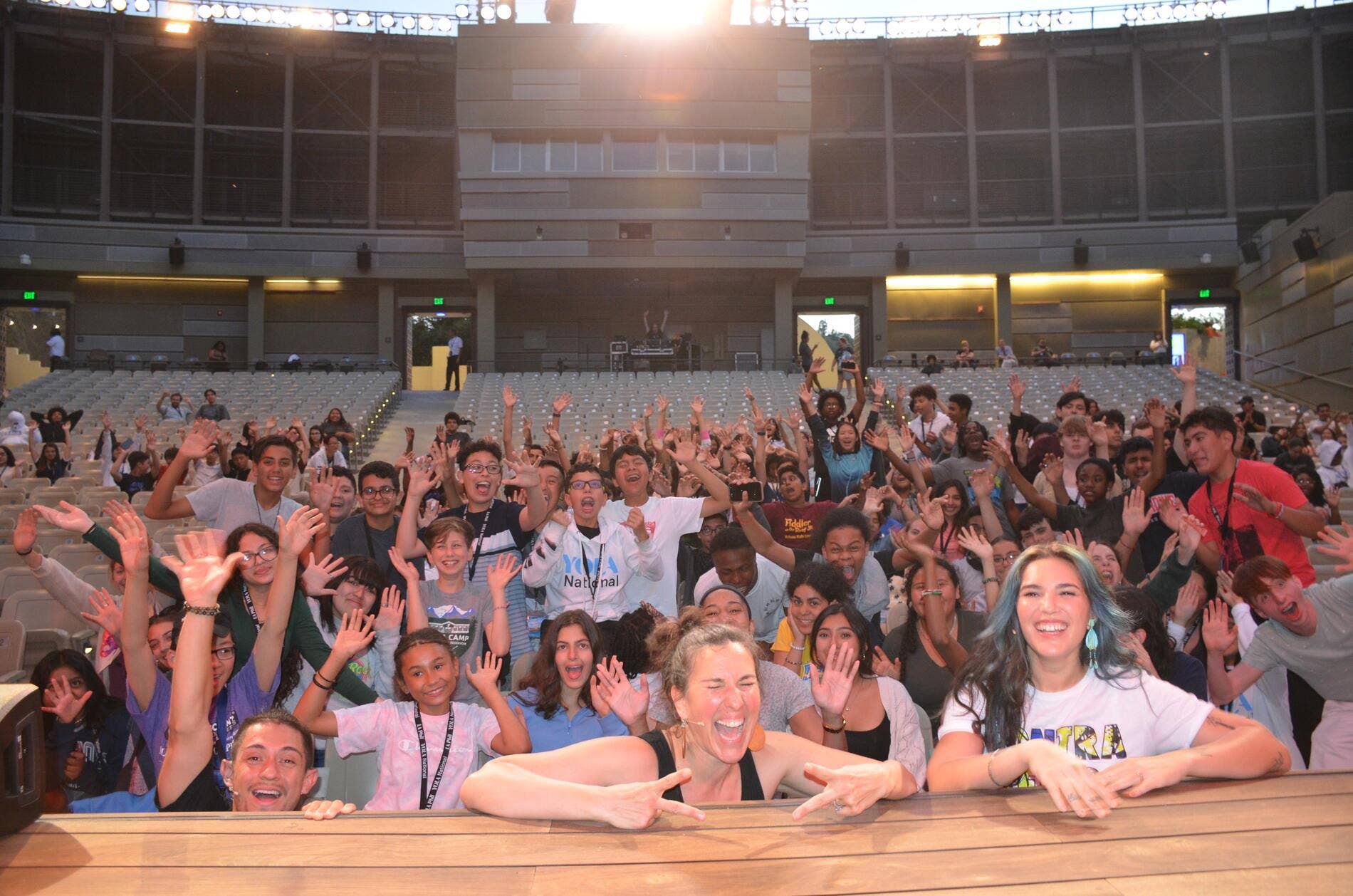 A large group of young musicians cheering and facing the stage at the Ford.