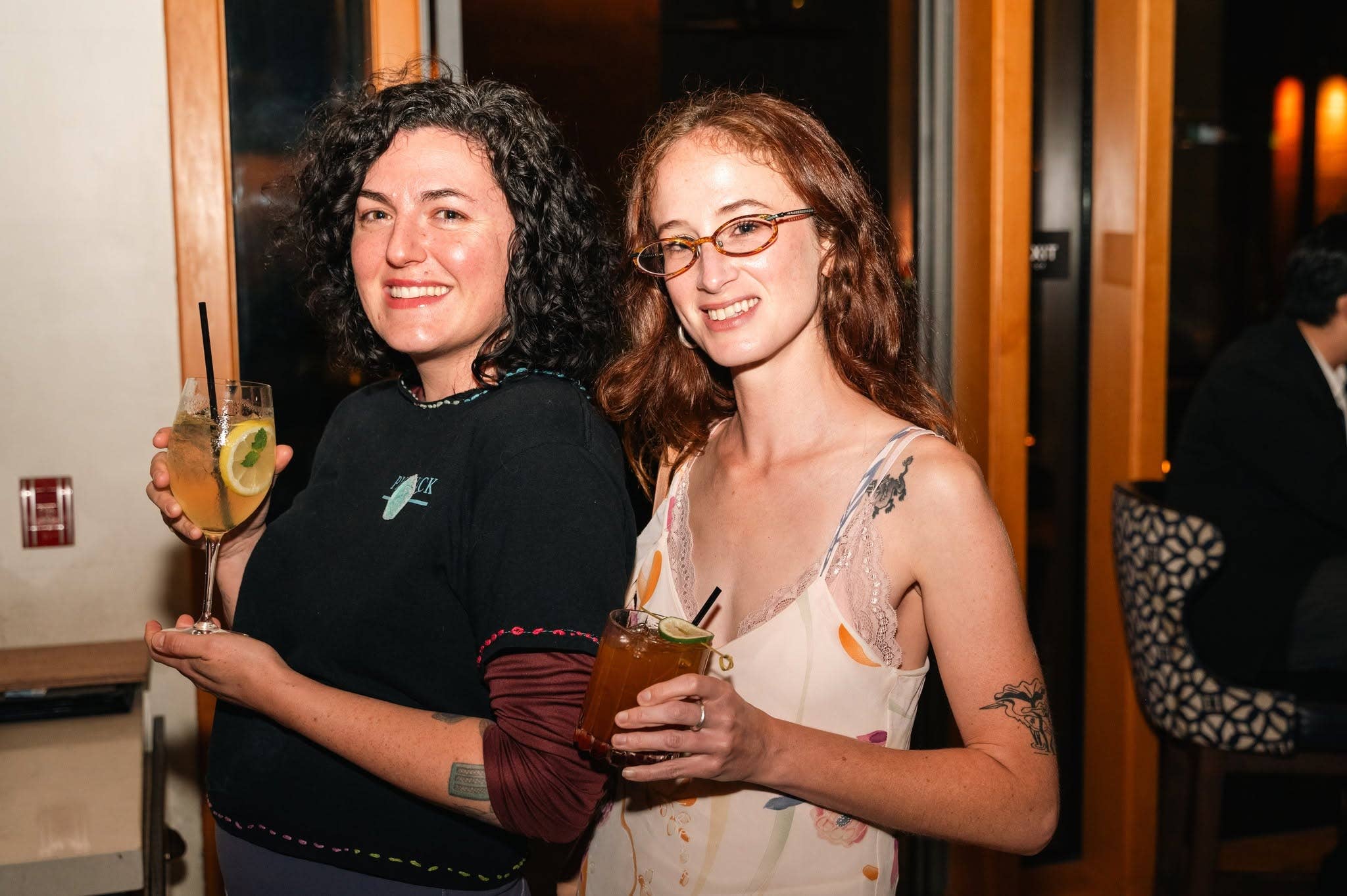 Two women with wine and cocktails at a CODA event.