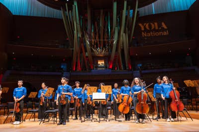 YOLA National students stand on stage after a performance at the Walt Disney Concert Hall.