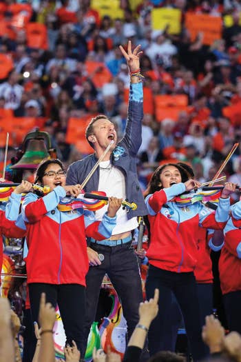 YOLA students play violins next to Chris Martin during a Coldplay Superbowl concert in 2016.