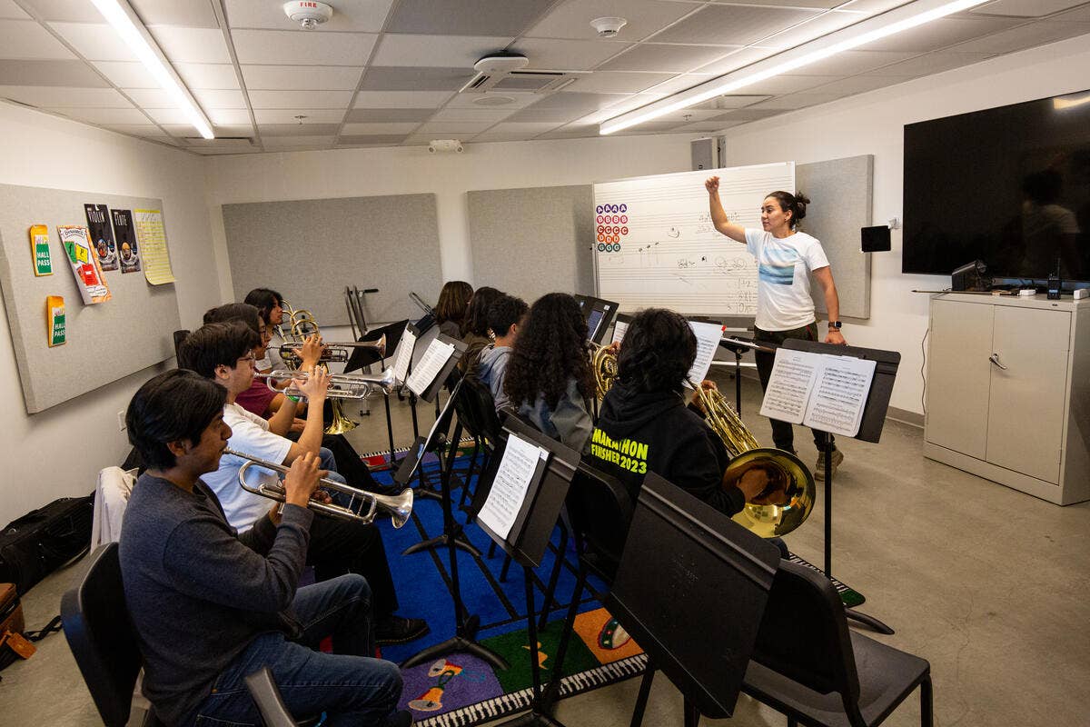 YOLA at Inglewood students rehearse in a practice room with their instructor conducting. 