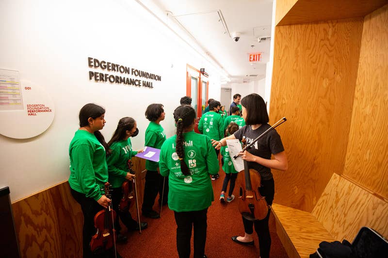 YOLA Institute Children's Orchestra and Youth Orchestra students wait in the wings before performing during a concert.