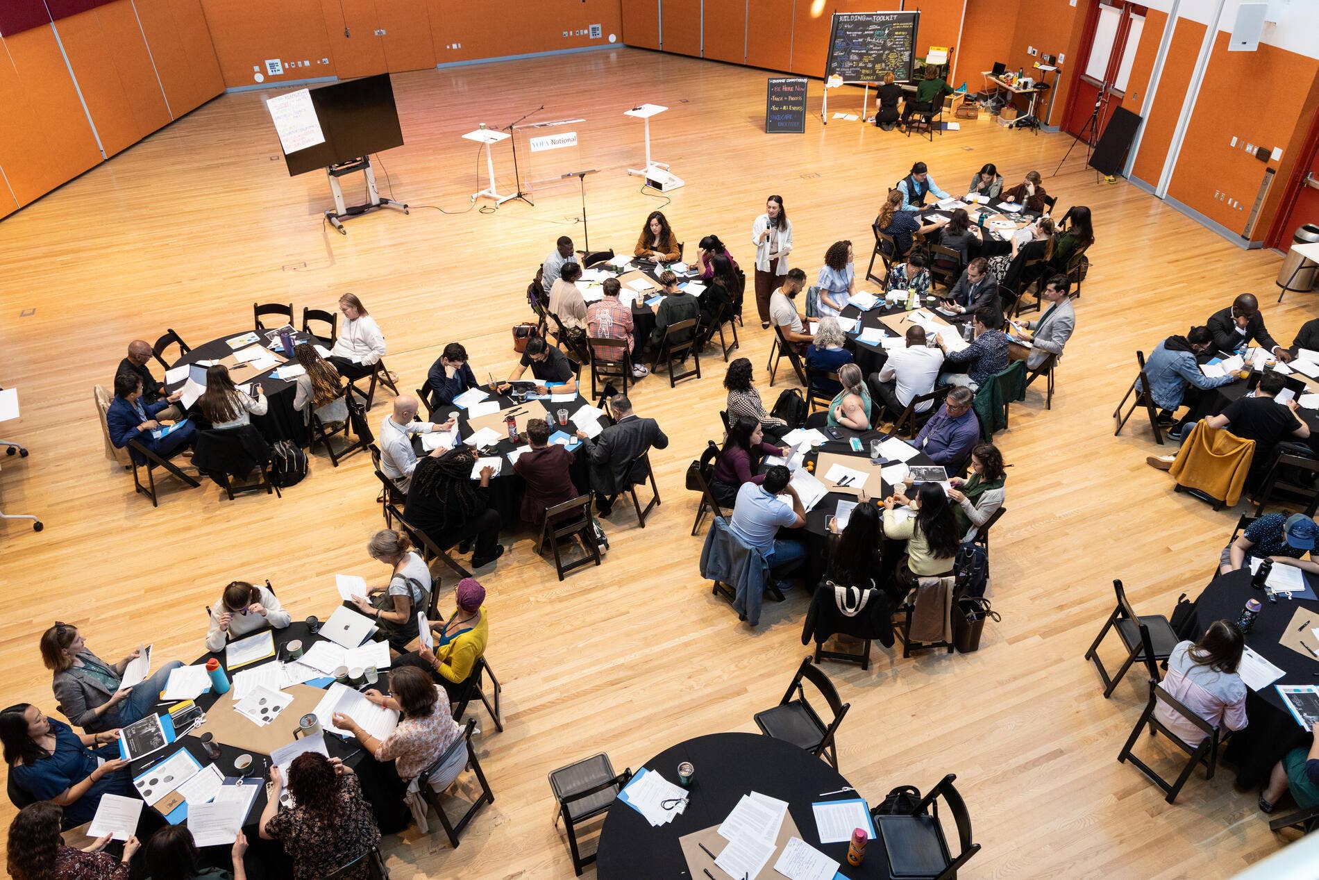 An aerial perspective of several tables with attendees during a YOLA National Accelerator workshop.