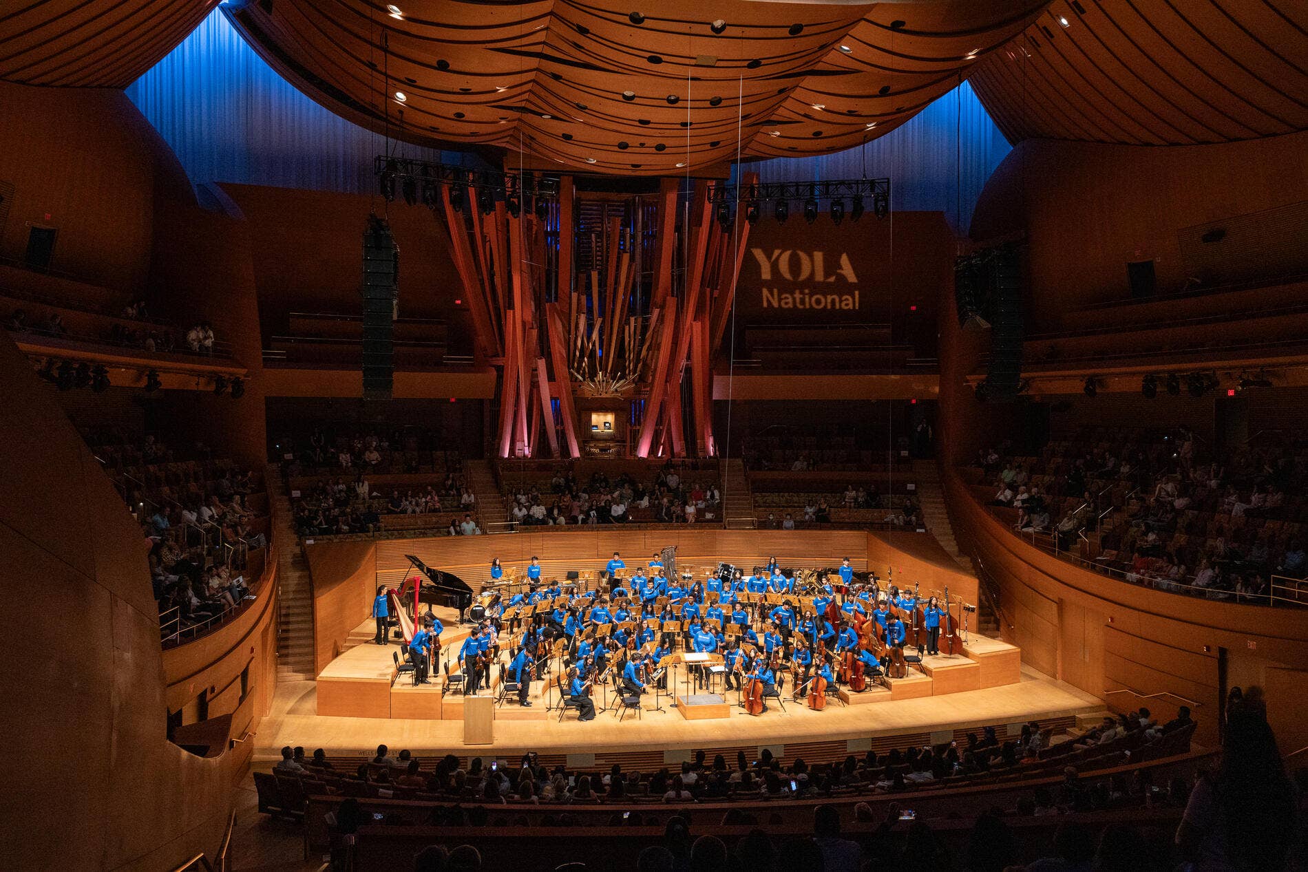 A photo of the YOLA National musicians on stage at Walt Disney Concert Hall during a performance.