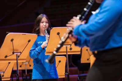 A YOLA National student plays the clarinet during a performance.