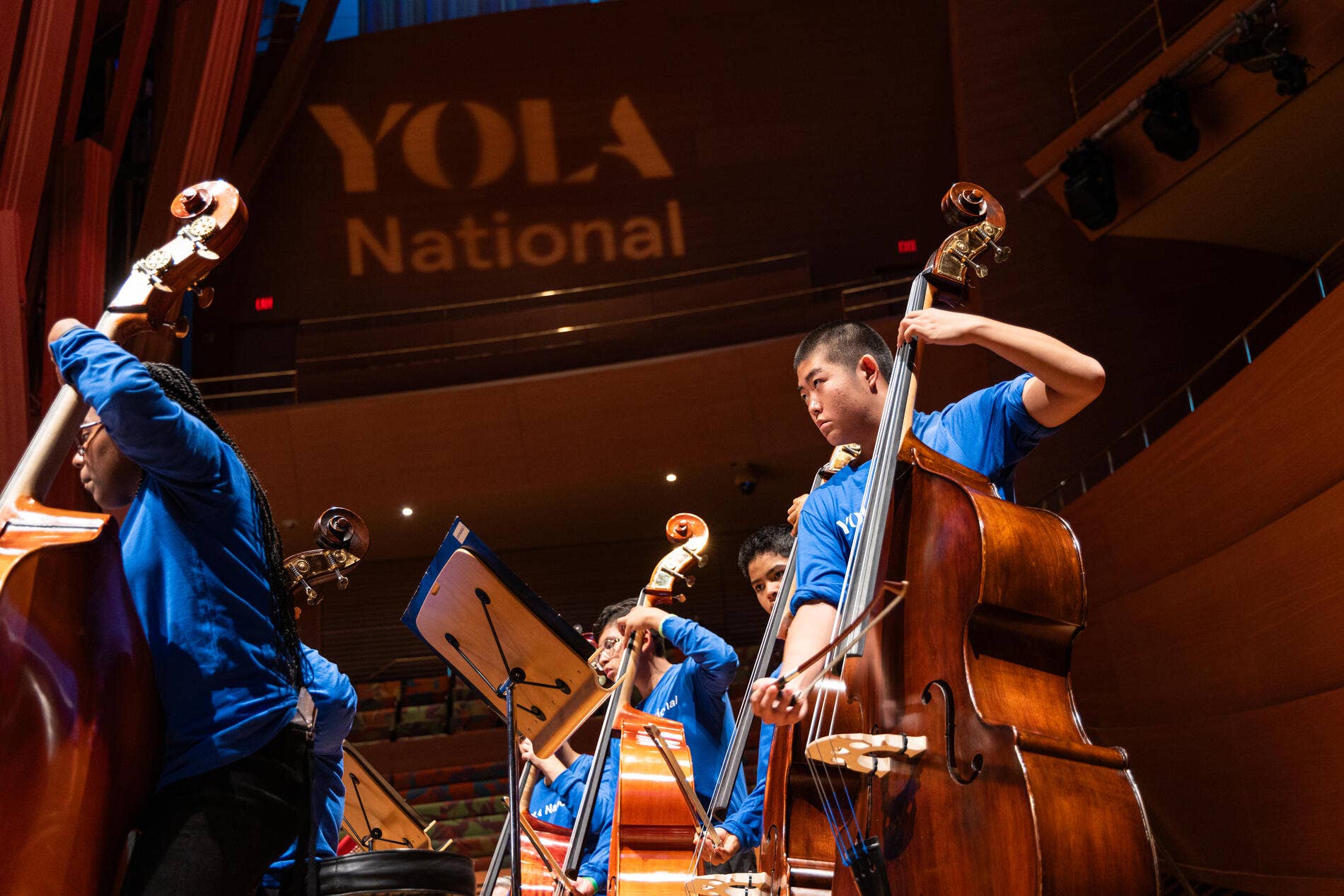 YOLA National students play their upright bass instruments during a performance in the Walt Disney Concert Hall.