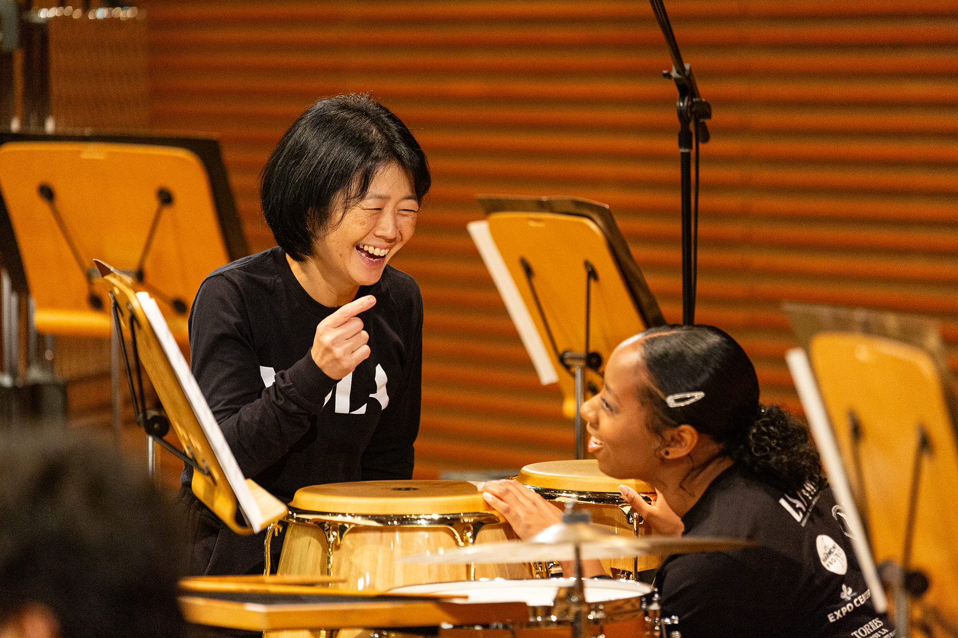 A YOLA Teaching Artist laughs with a YOLA student during a rehearsal break.