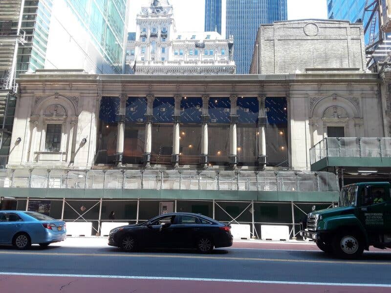 The Times Square Theatre under construction with scaffolding outside.