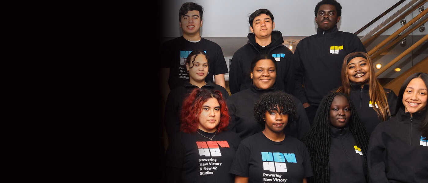 A group of New 42 Youth Corps members stand in rows and smile. 