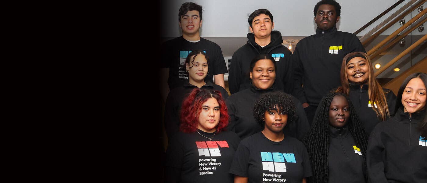 A group of New 42 Youth Corps members stand in rows and smile.