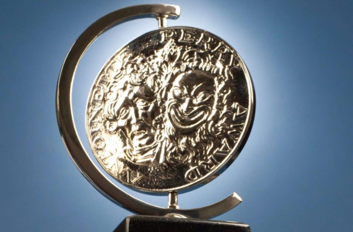 Close-up of a Tony Award, mounted on a stand against a blue sky background