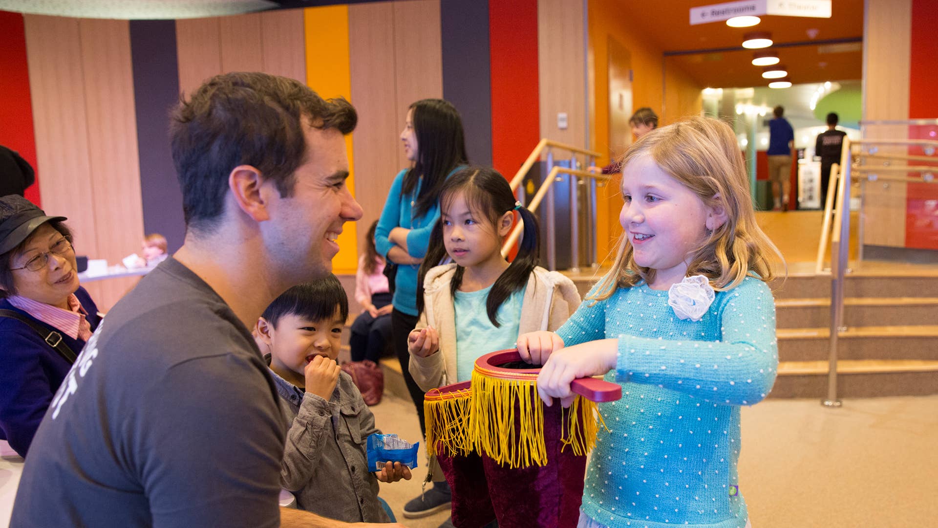 New Victory Teaching Artist leads a young girl in a pre-show magic activity.