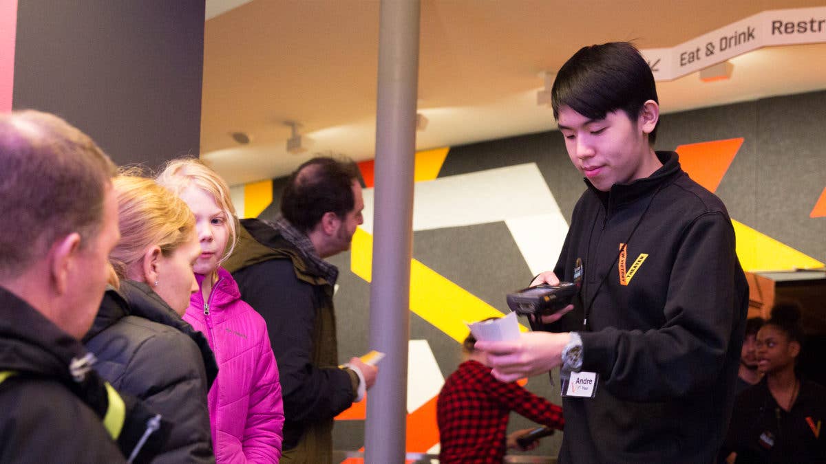 A member of the New Victory Usher Corps scans a family's tickets.