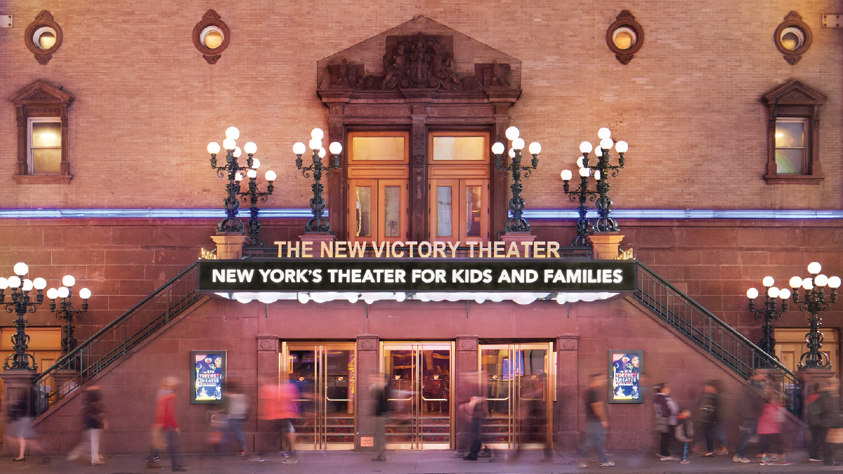 Entrance and fully-lit marquee of the New Victory Theater that reads 