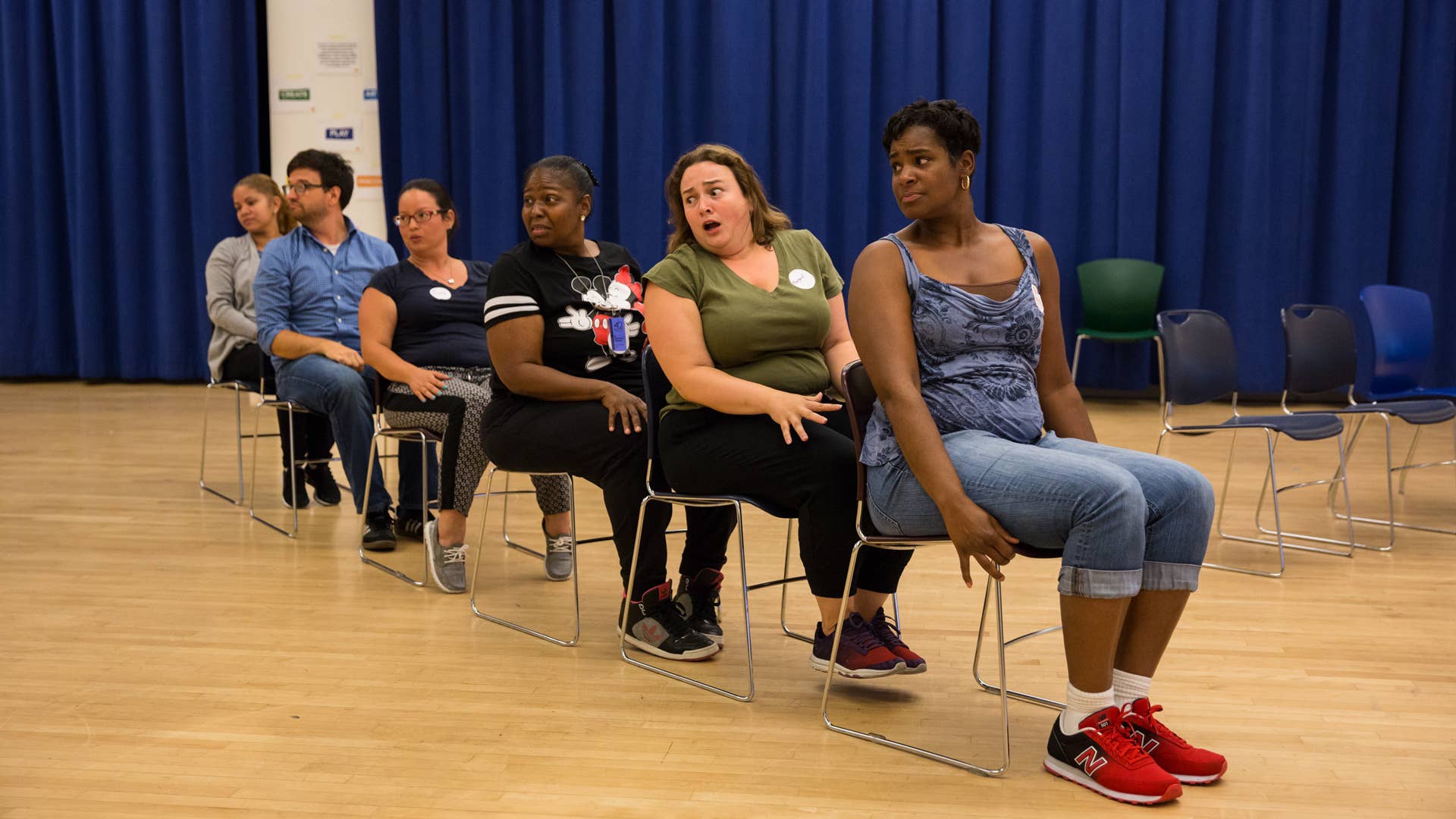 Teachers sitting on chairs in a straight line