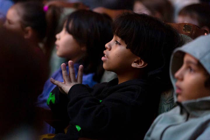 Audience members at a student matinee raptly watch a show.