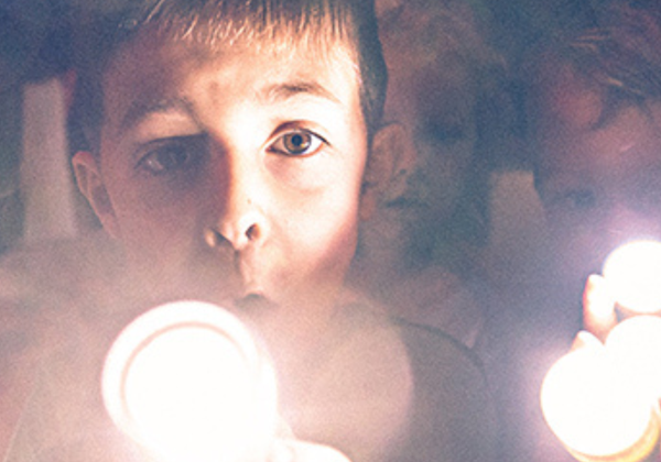 Two kids with flashlights at a performance of FORTS
